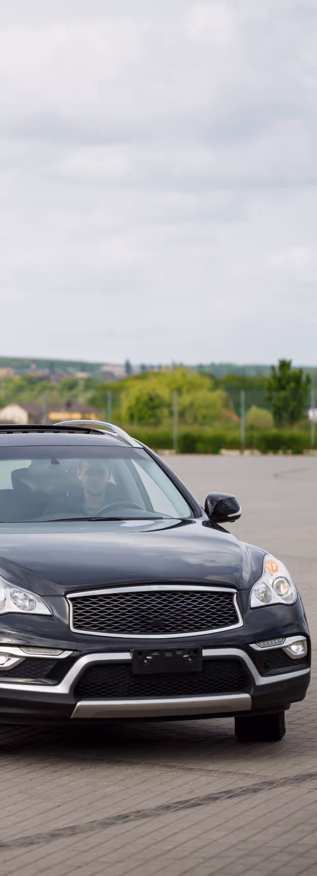 A young man driving a black car
